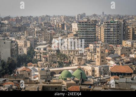 The aerial view of the downtown of Tripoli, the city in northern Lebanon, with the dusty streets, numerous building, houses, and Mediterranean sea. Stock Photo