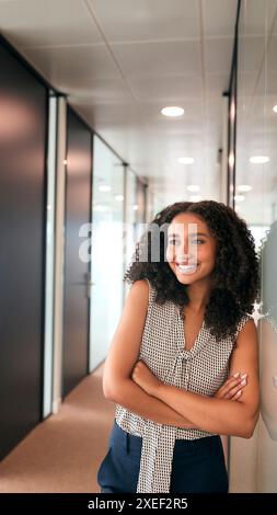 Portrait Of Smiling Businesswoman Standing In Corridor Of Modern Office Building Stock Photo