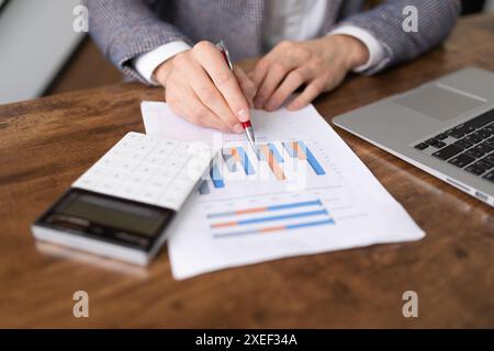 Financial analyst with diagrams of the affairs of the company notes the successes on the sheets Stock Photo