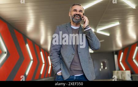 Horizontal photo of mature adult male boss with gray hair and beard talking on the phone Stock Photo