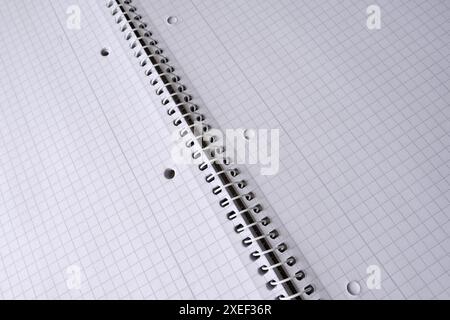 Top view of opened checkered notebook on a spiral for a notice in school or office, close-up. Free space for text. Business or education concept Stock Photo