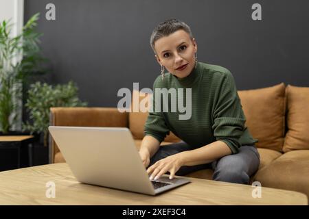 Woman remotely working on a laptop for a professional project Stock Photo