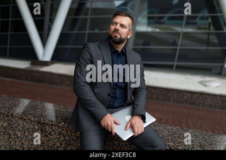 Pensive male architect with documents on the background of the built object Stock Photo