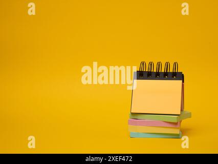 Stack of paper multi-colored stickers on a yellow background Stock Photo