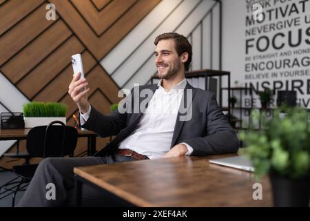 Portrait of a joyful financier in the office checking the news on the phone Stock Photo