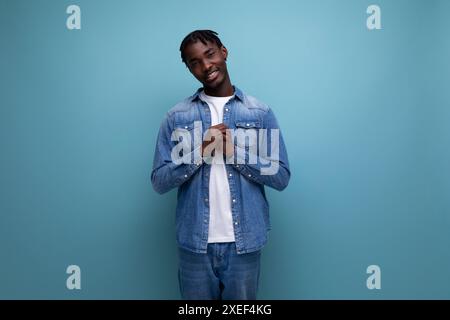 Handsome american man with afro curls in casual denim outfit on blue background with copy space Stock Photo