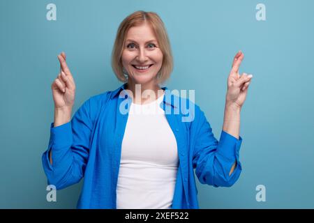 Energetic 50s woman in an attractive look on a blue background with copy space Stock Photo