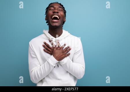 Joyful winner african 20s man with dreadlocks on background with copy space Stock Photo