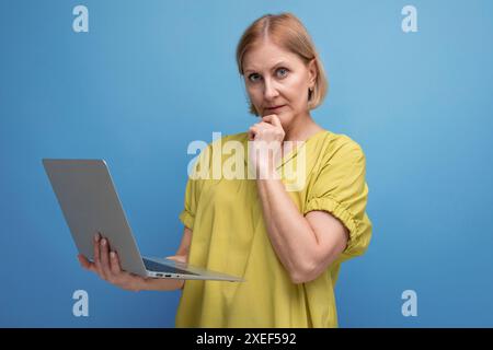 Pensive middle aged business woman freelancing using laptop and internet connection Stock Photo