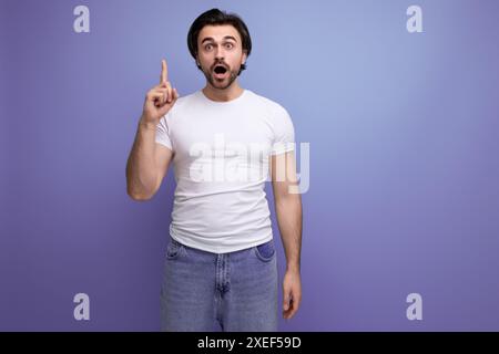 Smart young brutal brunette man in white t-shirt and jeans with some idea Stock Photo