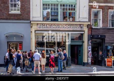 Tourists on London rock music walking tour in Denmark Street, the traditional home of the British pop music scene. Stock Photo