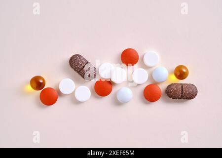 Pills, vitamins and dietary supplements on a beige background. Stock Photo