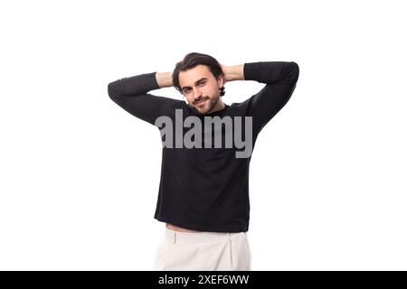 Young bearded brutal european macho man with ear piercing and with black hair on isolated white background with copy space Stock Photo