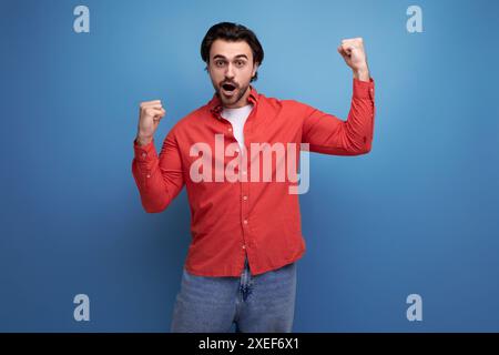Young european handsome guy with a stylish hairstyle rejoices Stock Photo
