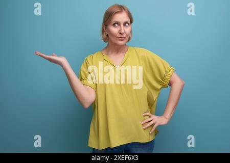Middle aged woman with insight points finger to the side in studio Stock Photo