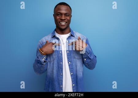 Smart young american man in denim jacket is inspired by an idea on a blue background with copy space Stock Photo