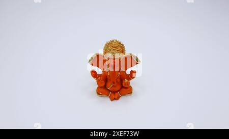 Beautiful Lord Ganesha idol on white background. Orange, saffron coloured ganpati murti statue Stock Photo