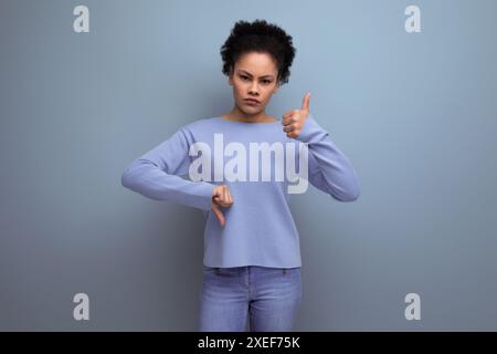 Portrait latina brunette woman with wavy hair in blue stylish casual clothes with doubt gesture Stock Photo