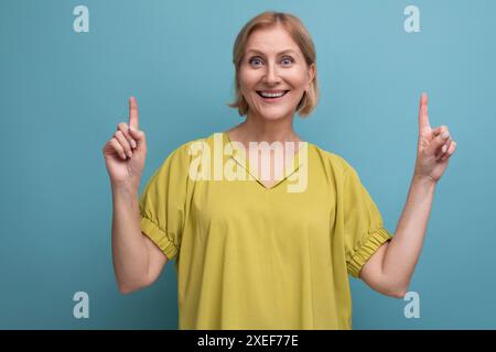 Middle aged woman with insight points finger to the side in studio Stock Photo
