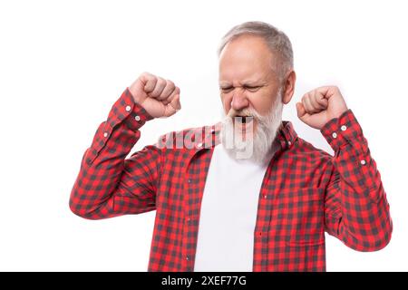 Joyful lucky 60s retired man with white beard and mustache in red shirt Stock Photo