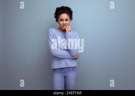 Close up of pretty young 20s woman with dark puffy hair isolated background with copy space Stock Photo