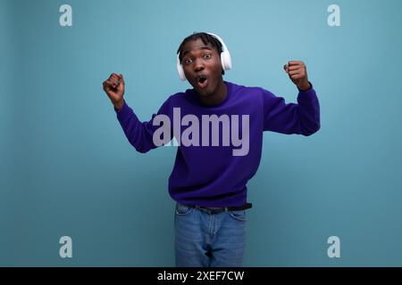 Energetic american young man with dreadlocks dancing to music with headphones Stock Photo