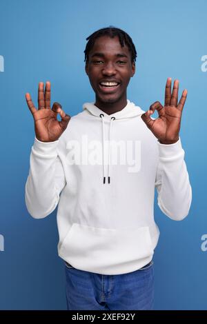 Positive dark skinned young brunette male with hollywood smile on studio isolated background Stock Photo