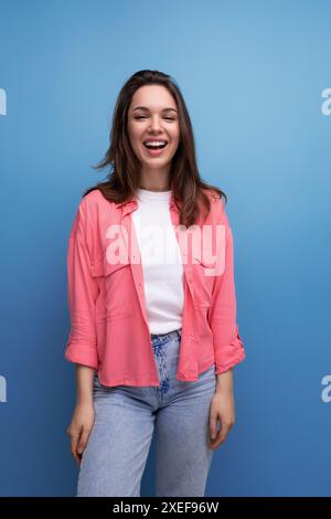 Vertical portrait of brunette young woman in shirt and jeans Stock Photo