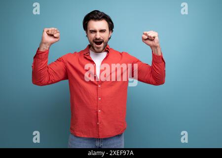 Handsome confident dark haired 30s man in red shirt Stock Photo