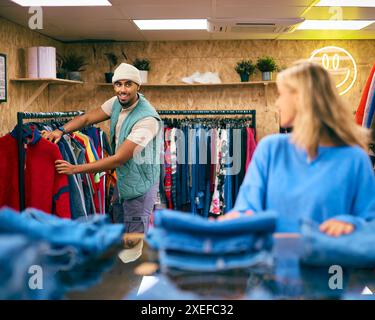 Couple Or Sales Assistants Working Or Looking At Clothes In Pop Up Fashion Store Stock Photo