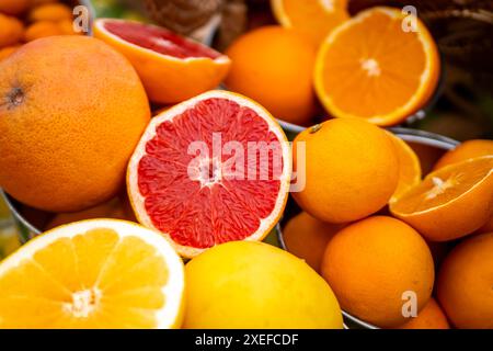 Delightful assortment of organic citrus fruits, featuring oranges, grapefruits, lemons, with some halved to showcase their juiciness. Stock Photo