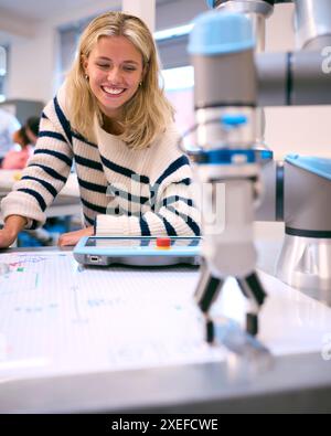Female College Or University Engineering Student In Robotics Class Working On Robotic Arm Stock Photo
