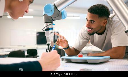 Two Male College Or University Engineering Students In Robotics Class Working On Robot Arm Stock Photo