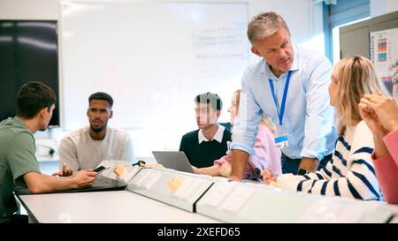 Male Tutor In Science Classroom Teaching Group Of College Or University Engineering Students Stock Photo