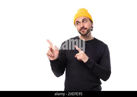 Brutal 30s authentic brunet male adult in black sweatshirt pointing finger at new strategy on white background with copy space Stock Photo