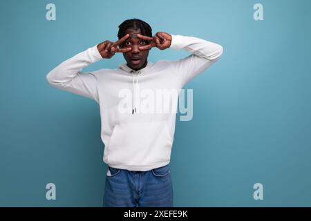 Model dark-skinned European young brunette man in a white hoodie Stock Photo