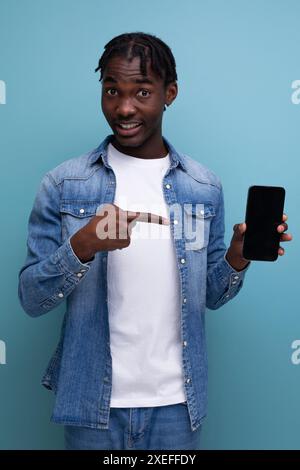 Smiling african man with black dreadlocks using smartphone Stock Photo