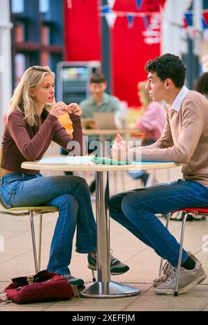 Male And Female College Or University Students Working Together At Table In Study Area Stock Photo