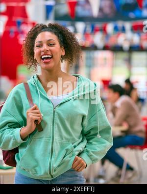 Portrait Of Smiling Female University Student Standing Inside College Building Stock Photo