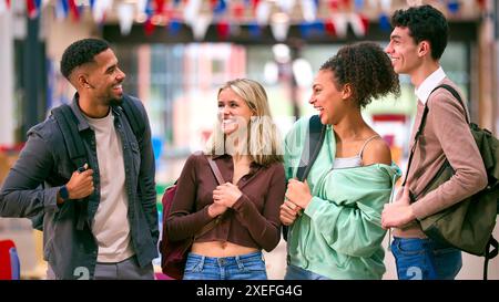 Group Of University Students With Bags Socialising In College Building Stock Photo