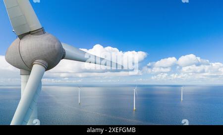 A single wind turbine stands tall in the middle of the vast ocean, harnessing renewable energy while surrounded by an endless ex Stock Photo
