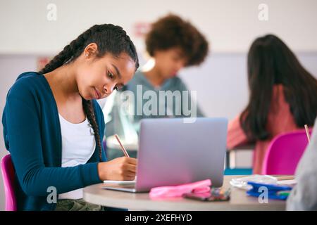 Female Secondary Or High School Pupil With Laptop Working In Study Area Stock Photo