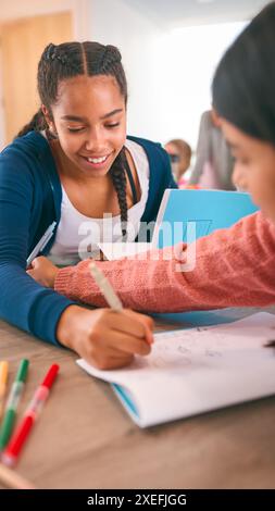 Two Female Secondary Or High School Students Collaborating In Study Area Stock Photo
