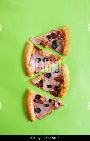 Pizza slices on a green background Stock Photo