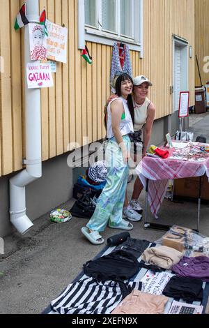 Young women selling used goods at Kumpula Village Party street fair pop-up flea market in Helsinki, Finland Stock Photo