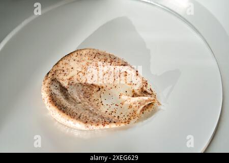 Sample of scrub cream with natural particles on a round stand. Stock Photo