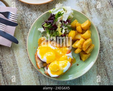 Portion of eggs benedict toast with salmon and potatoes closeup Stock Photo