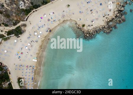 Drone view of idyllic sandy holiday beach. Konnos Bay beach people relaxing and enjoying summer holidays. Stock Photo