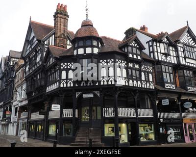 Old half timbered buildings on the corner of Eastgate and stairs leading to the upper rows Stock Photo