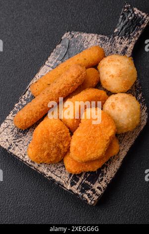 Delicious nuggets, sticks and balls of mozzarella and parmesan cheese with salt and spices Stock Photo